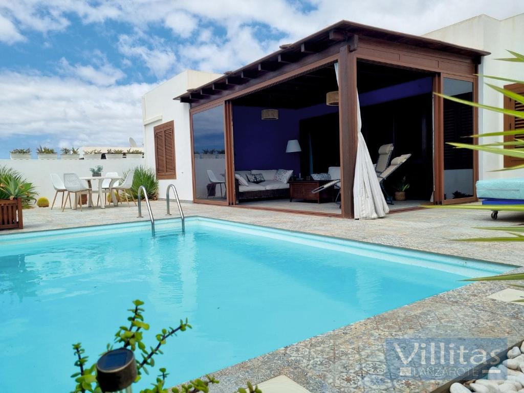 a swimming pool in a villa with a view of the water at VILLAZUL by Villitas in Playa Blanca