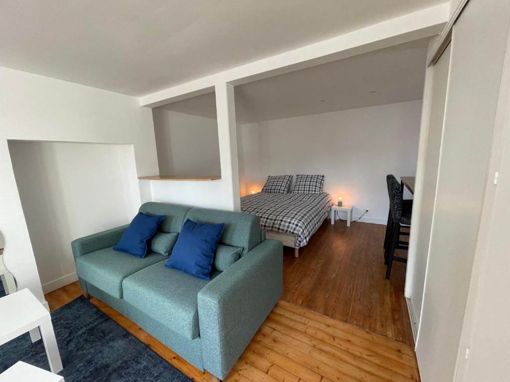 - un salon avec un canapé bleu et un lit dans l'établissement Les 4 saisons Honfleur - Studio 3, à Honfleur