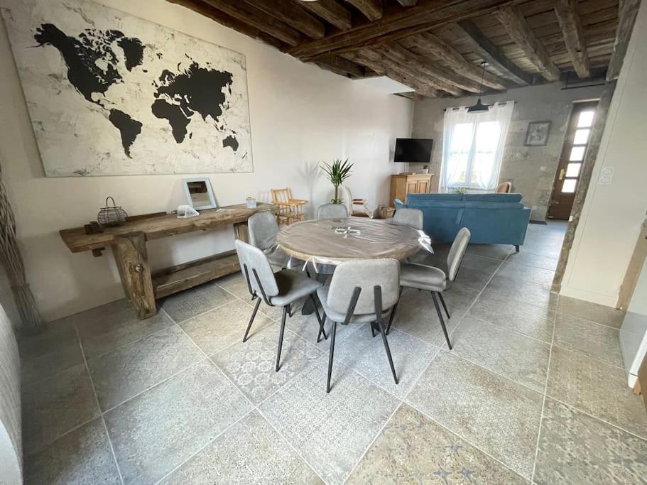 a table and chairs in a living room with a map on the wall at Côté Loire in Blois