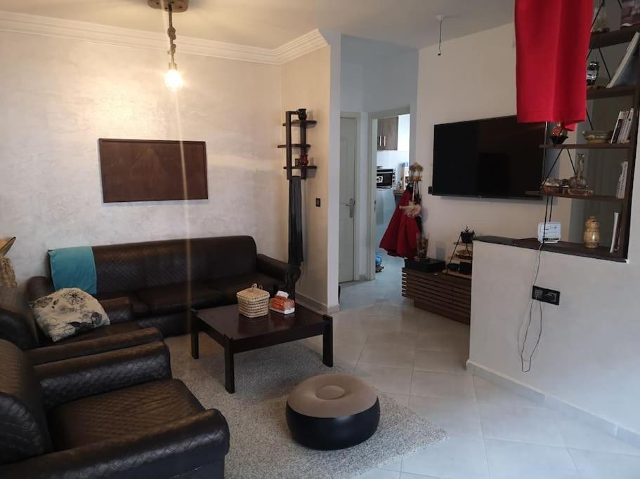 a living room with a couch and a tv at Your Sweet Appartment in Fez