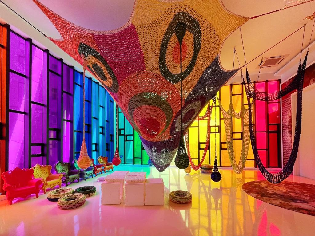 a room with colorful windows and tables and chairs at Arte Mont Kiara By The Relax Stay Kualalumpur in Kuala Lumpur