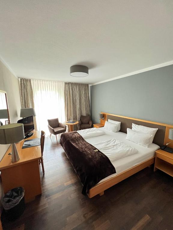 a hotel room with a large bed and a desk at Hotel Prinz in Munich