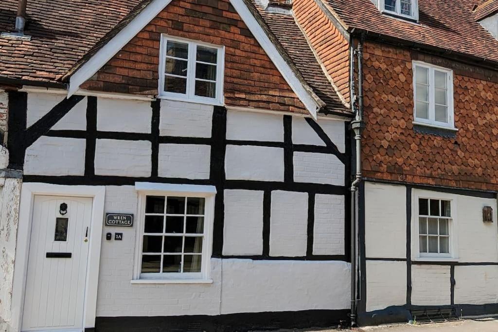 um edifício preto e branco com uma garagem branca em Cosy character cottage in central Marlborough UK em Marlborough