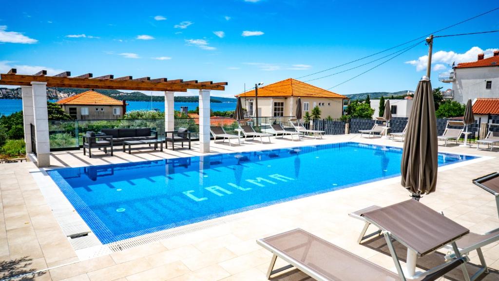 einen Pool in einer Villa mit Gartenmöbeln in der Unterkunft Calma apartments in Trogir