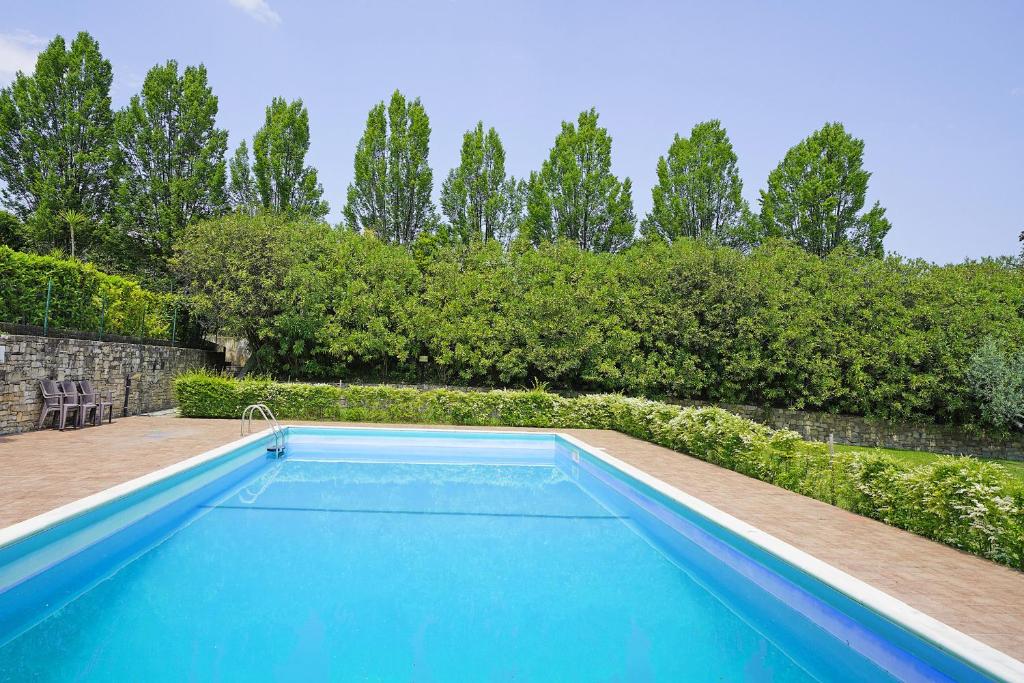 uma piscina azul num quintal com árvores em Casa Monte Cicogna PT-1 by Wonderful Italy em Moniga