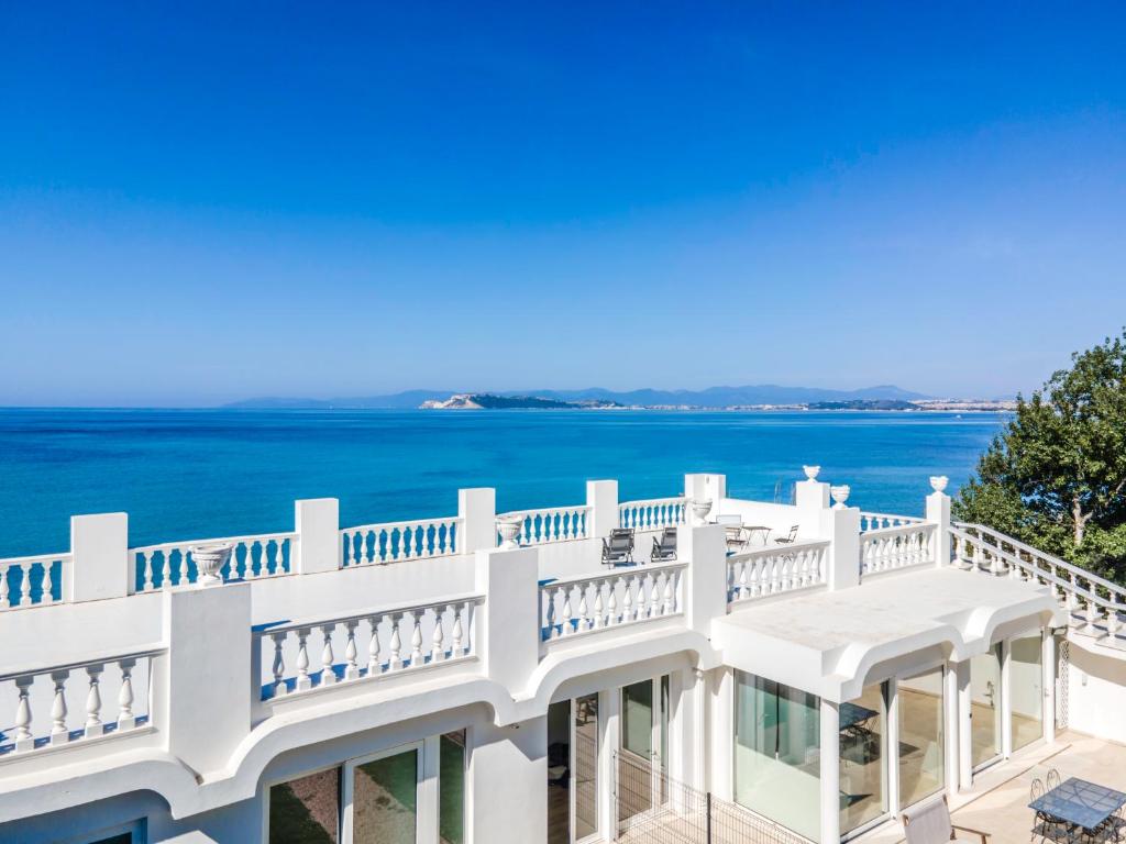 a white house with a balcony overlooking the ocean at Villa Blanca del mar in Quartu SantʼElena
