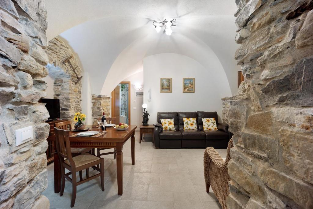 - un salon avec une table et un mur en pierre dans l'établissement Ca dei nonni, à Diano San Pietro
