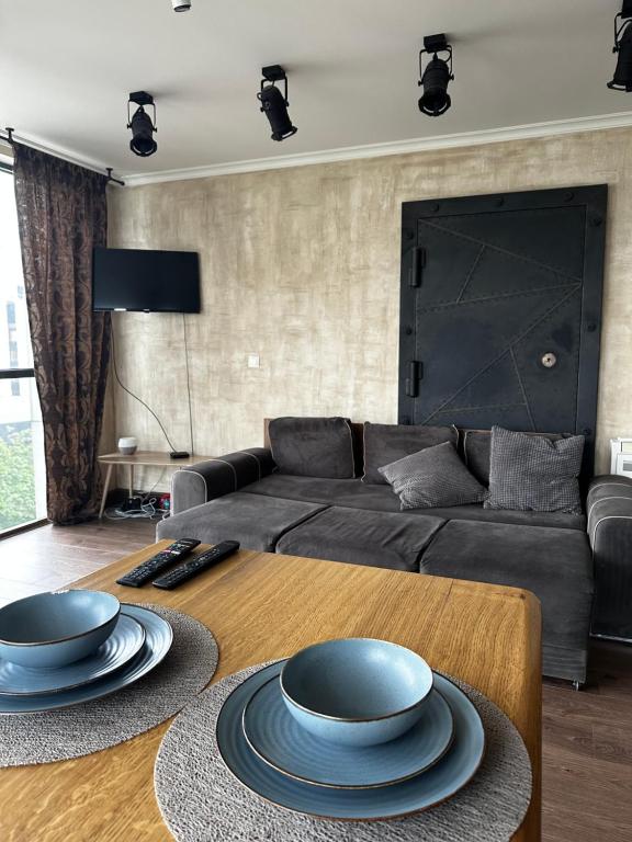 een woonkamer met een bank en een tafel met borden erop bij Apartment panorama center Varna in Varna