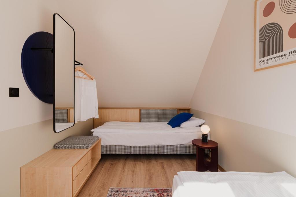 a small bedroom with two beds and a mirror at Płyniewoda - całoroczne domy PREMIUM, klimatyzacja, kominek, blisko morza in Dziwnów