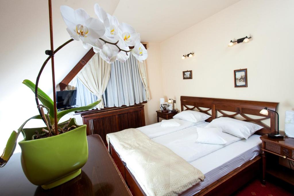 a bedroom with a bed and a plant in a vase at Pension Brasovu Vechi in Braşov