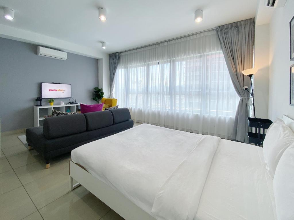 um quarto com uma cama branca e um sofá em Arte Plus Ampang By The Relax Stay Kualalumpur em Kuala Lumpur