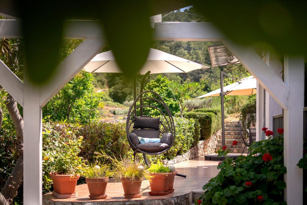 un columpio colgando de un porche con plantas en Stiniva Bay - Hvar Villa en Brusje