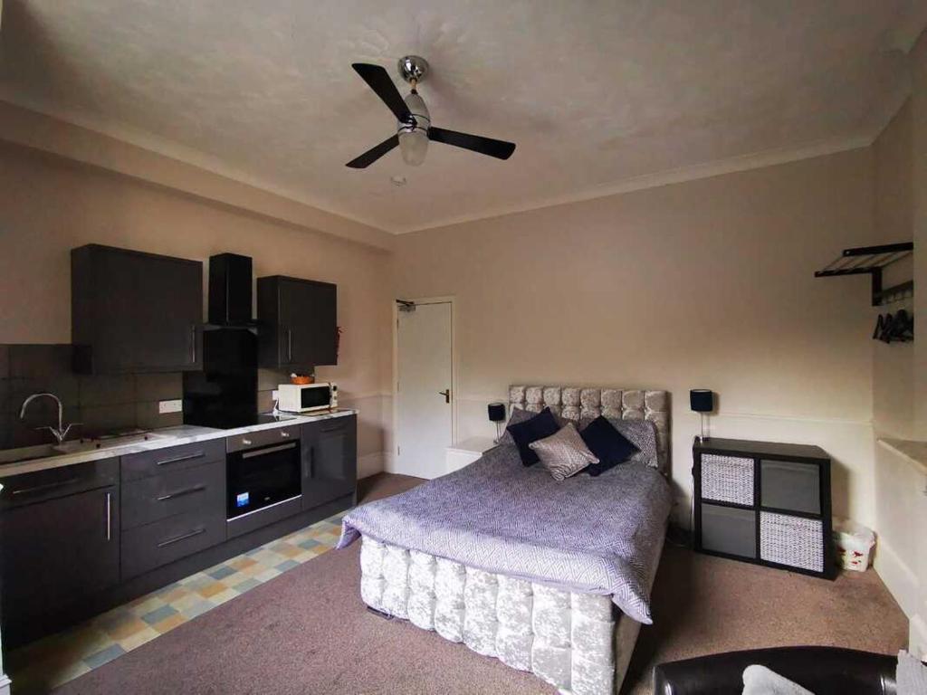 Schlafzimmer mit einem Bett und einem Deckenventilator in der Unterkunft The Victorian lodge in Ryde