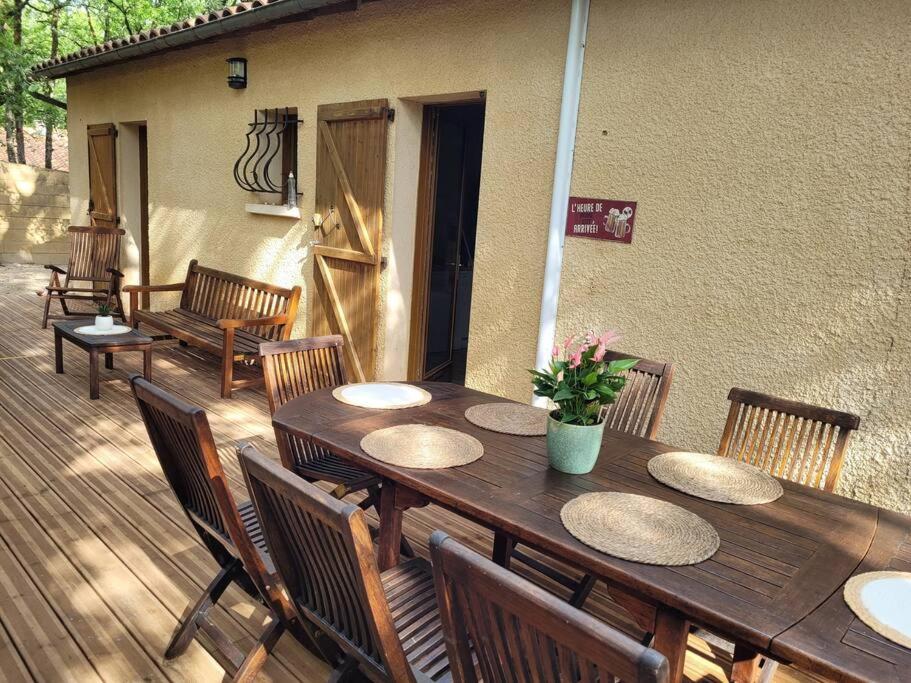 a wooden table and chairs on a deck at Maison conviviale in Nadaillac