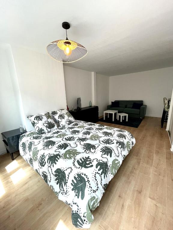 une chambre avec un lit avec une couverture noire et blanche dans l'établissement Les 4 saisons Honfleur - Studio 1, à Honfleur