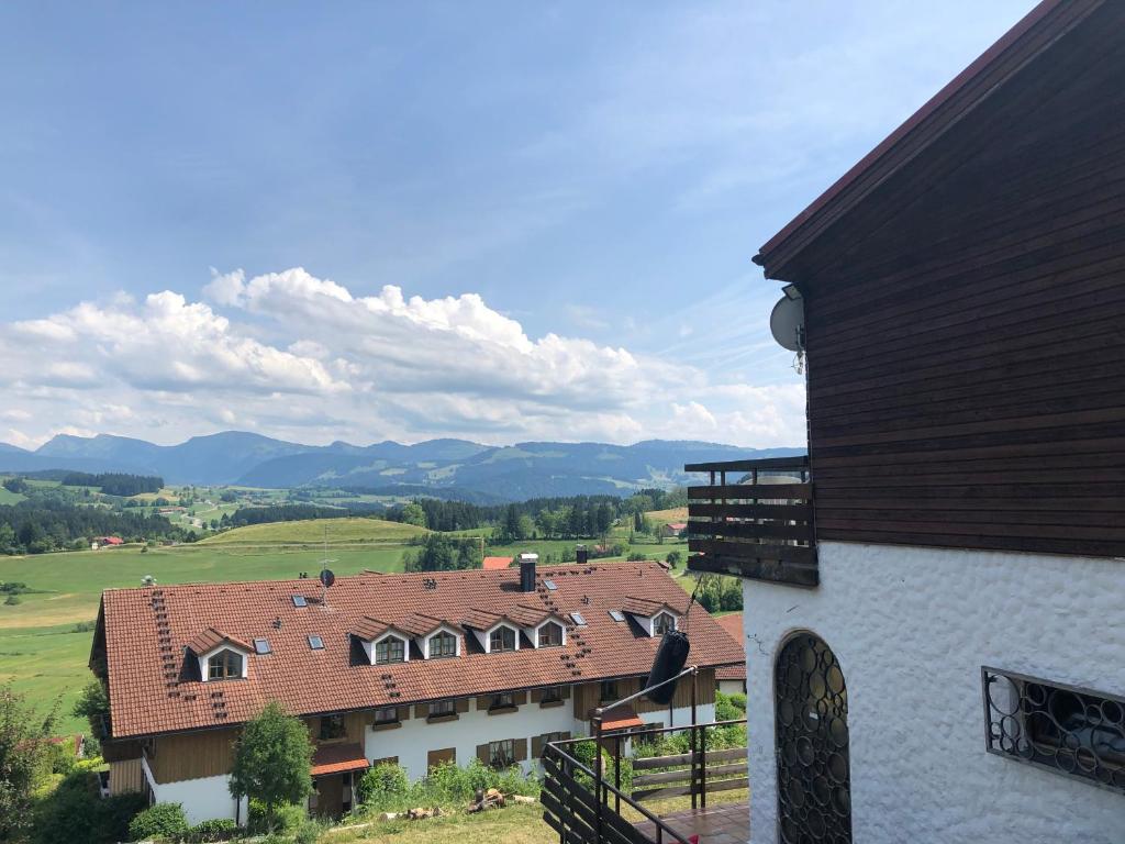 uma vista para uma casa com montanhas ao fundo em PanoramaApart - Alpzeit im Westallgäu em Oberreute