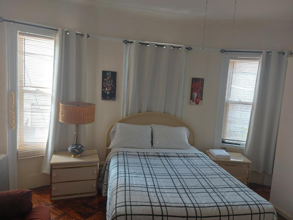 ein Schlafzimmer mit einem Bett mit einer karierten Decke in der Unterkunft Crsytal Chateau Room Rental in Brooklyn