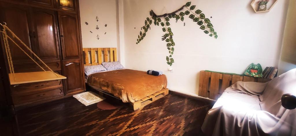 Zimmer mit einem Bett und Holzboden in der Unterkunft Irania House - Hermoso departamento con estilo diferente in Loja