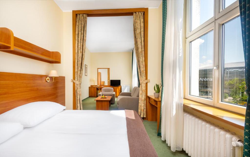 ブダペストにあるHotel Millenniumのベッドと窓が備わるホテルルーム