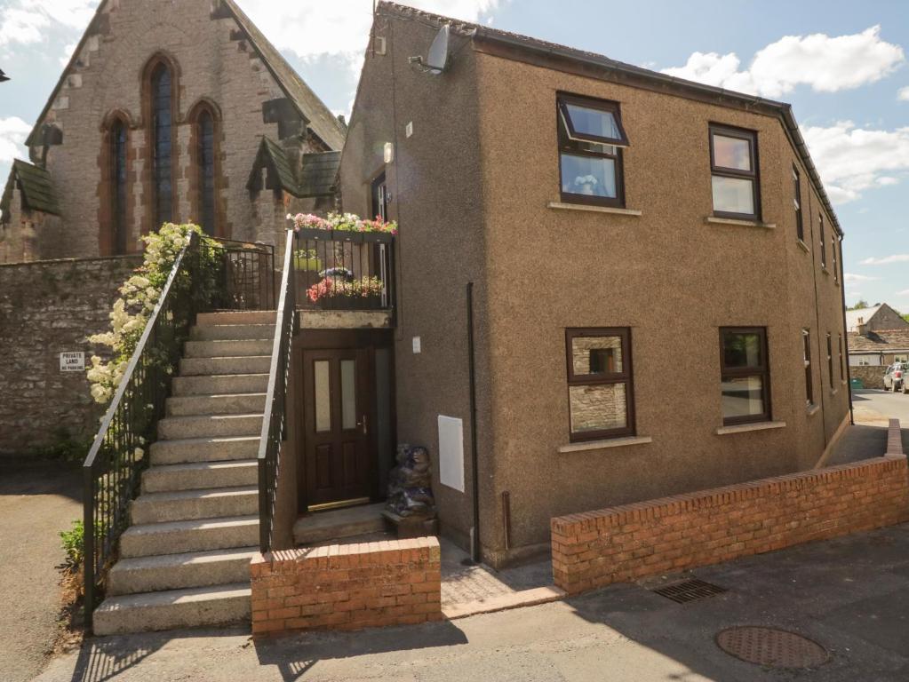 a brick building with a staircase in front of it at Muddy Boots - Scarpa in Kirkby Stephen