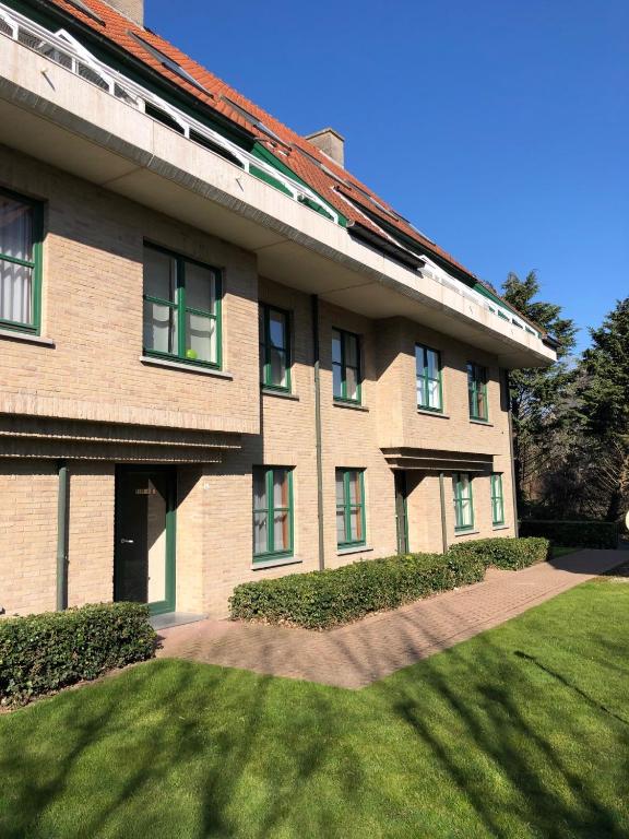 a large brick building with a green lawn in front of it at Peppino II 0202 - 3 bedrooms 6p - penthouse sunny terraces in Sint-Idesbald