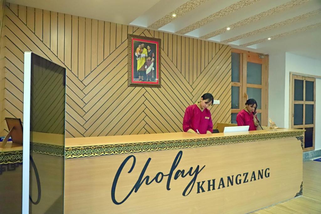 two people standing at the counter of a cheery kkinatownkarmaarma at Cholay Khangzang in Thimphu
