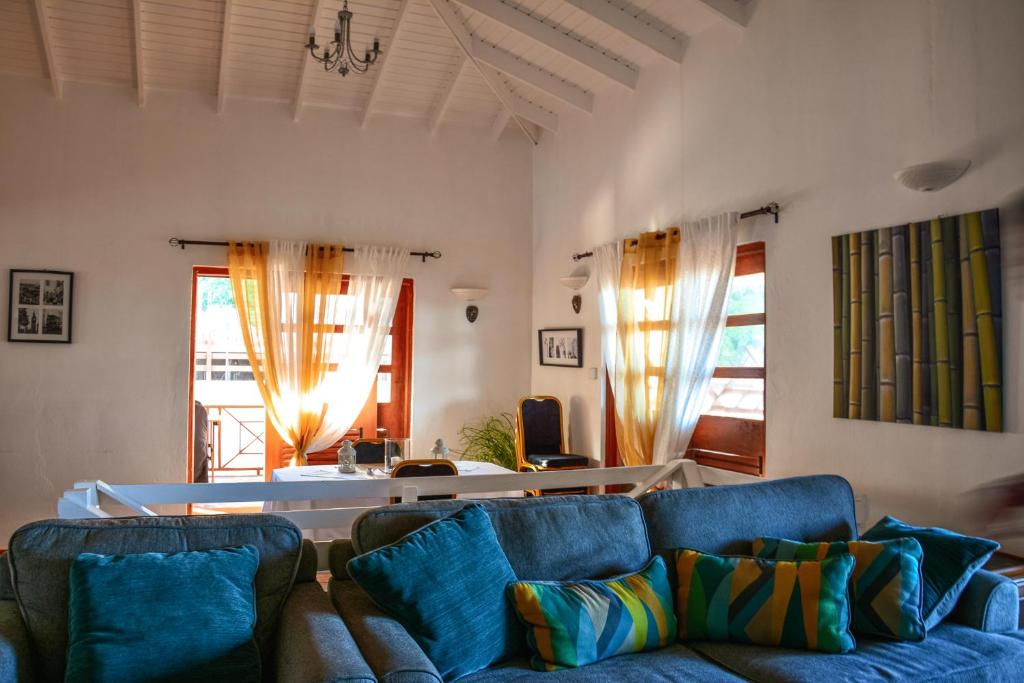 a living room with a blue couch and two windows at The Milligan in Kingstown