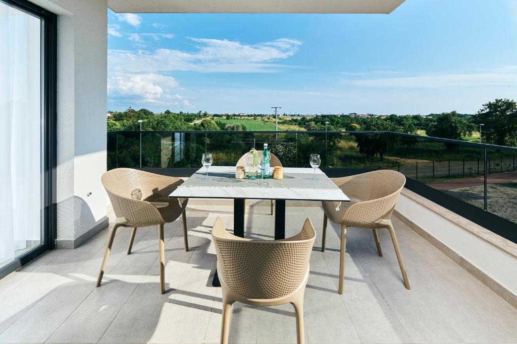 a table and chairs on a balcony with a view at Apartments San Maris in Umag
