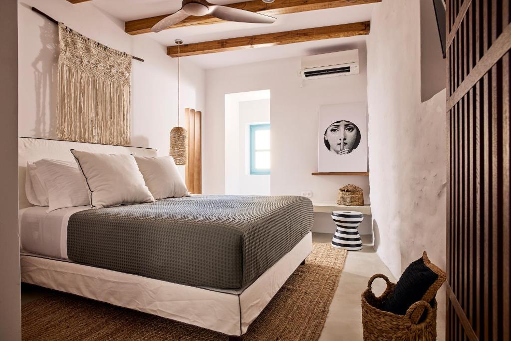 a bedroom with a bed and a ceiling fan at Syroc Maison in Ermoupoli