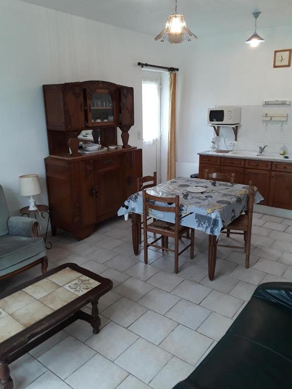 ein Wohnzimmer mit einem Tisch und einem Sofa in der Unterkunft L'ecole in Chuffilly-Roche