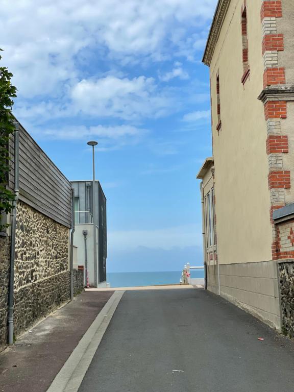 an empty street with the ocean in the background at Villa Blanche in Agon-Coutainville