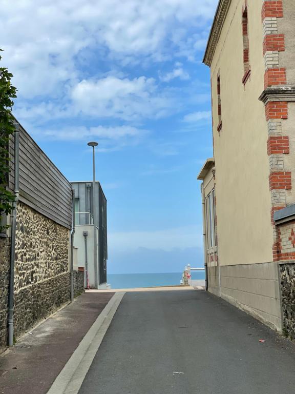 an empty street with the ocean in the background at Villa Blanche in Agon Coutainville