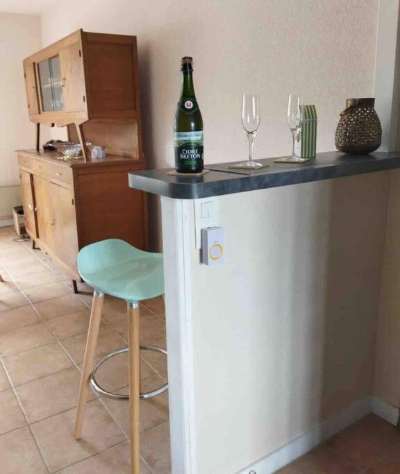 a bottle of wine sitting on a counter with two wine glasses at Maison de plein pied, 80m2, 2 ch., jardin clos in Quiberon