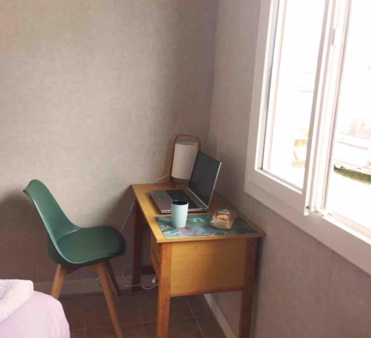 a desk with a laptop and a green chair in a room at Maison de plein pied, 80m2, 2 ch., jardin clos in Quiberon