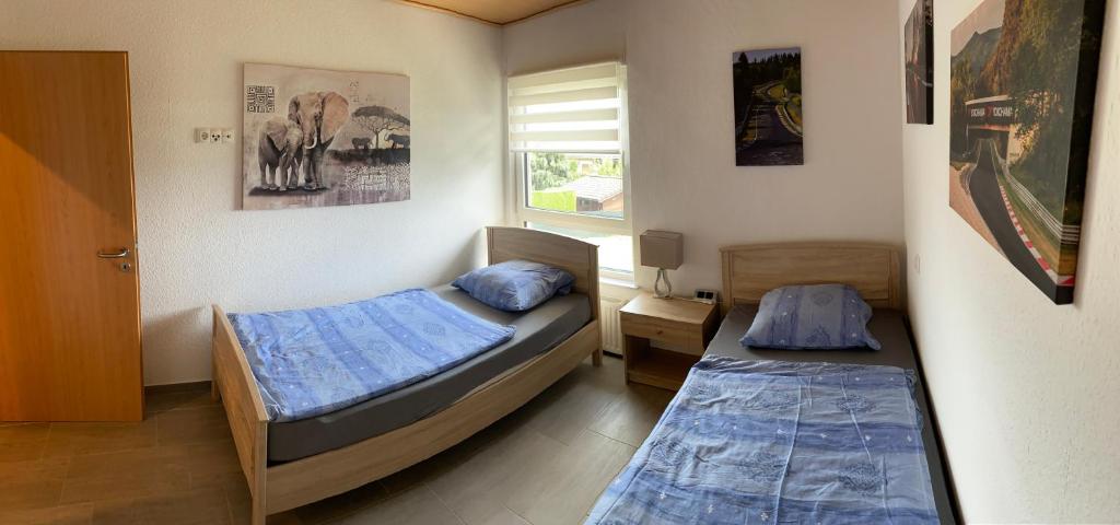 1 dormitorio con 2 camas y ventana en Alte Tankstelle, en Straßenhaus