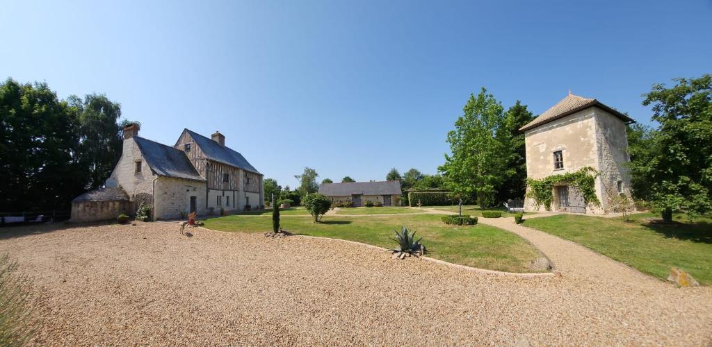 an old stone house with a pathway leading to it at La tour du Grand Boust in Longué