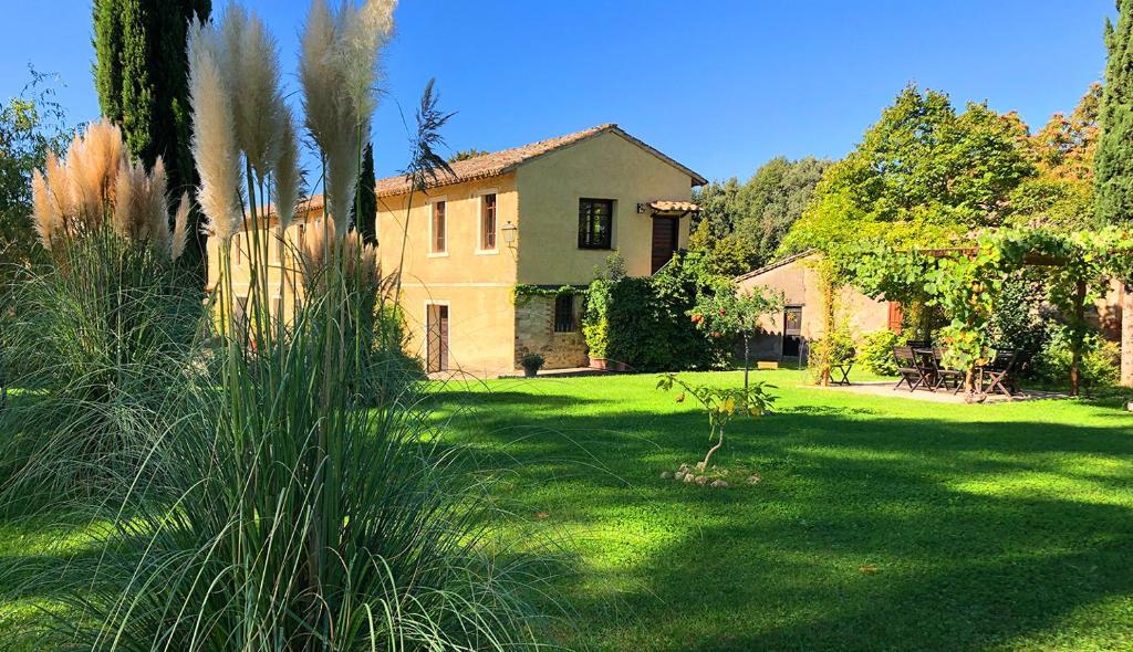 a large yard with a house in the background at Country Loft at Palazzo di Bagnaia in Castel del Piano