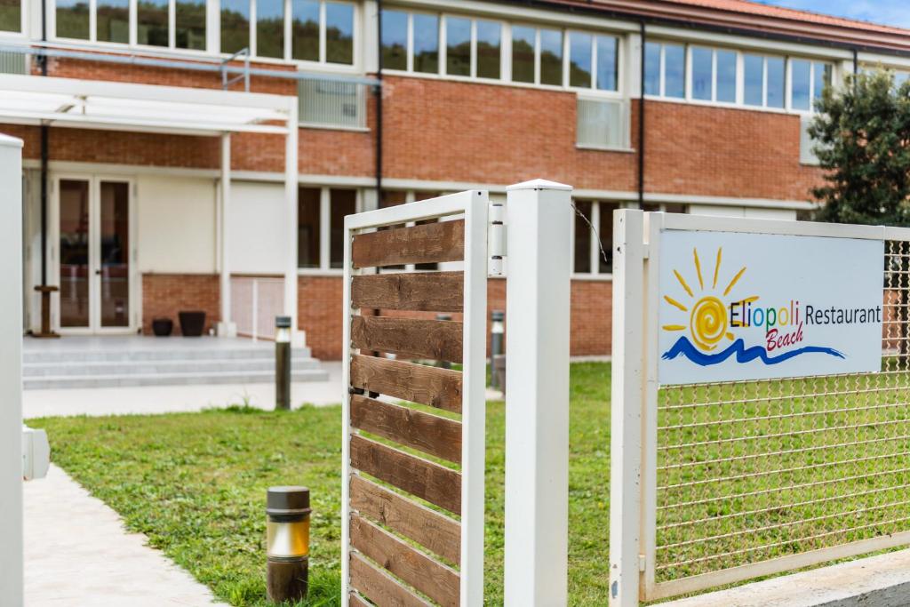 a school building with a sign in front of it at Eliopoli Beach Hostel & Restaurant in Tirrenia