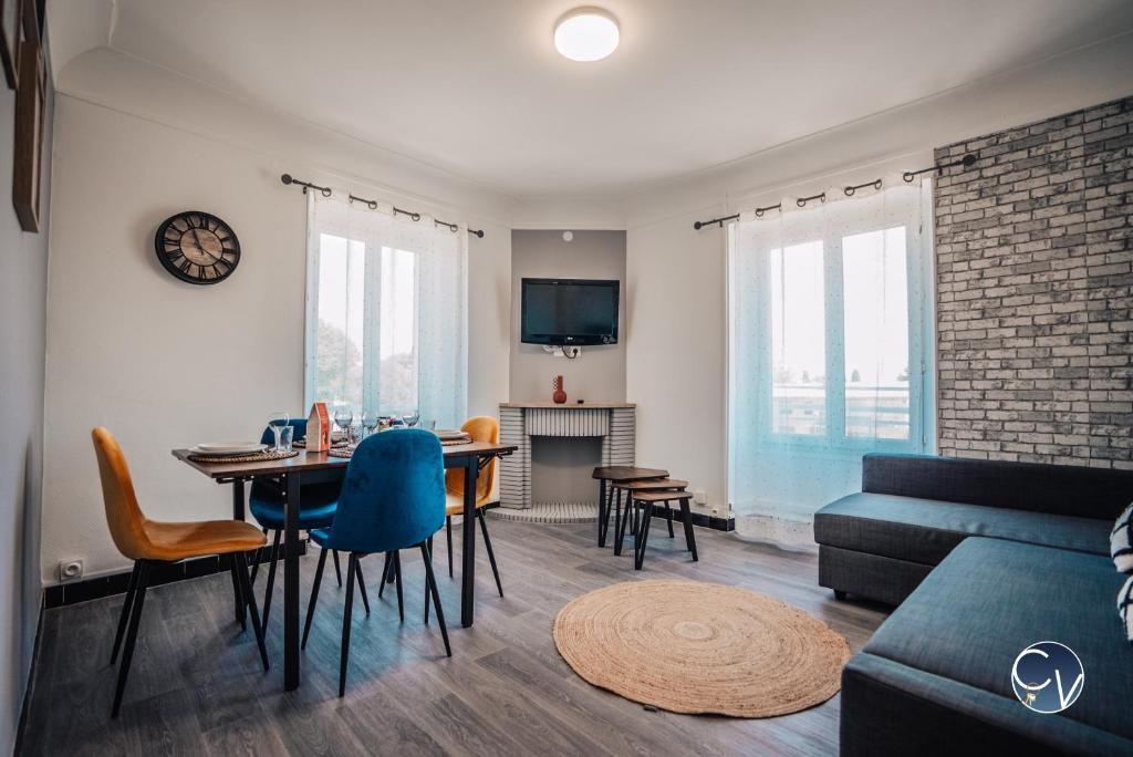 ein Wohnzimmer mit einem Tisch und einem Sofa in der Unterkunft Superbe Appartement centre ville in Pont-Saint-Esprit