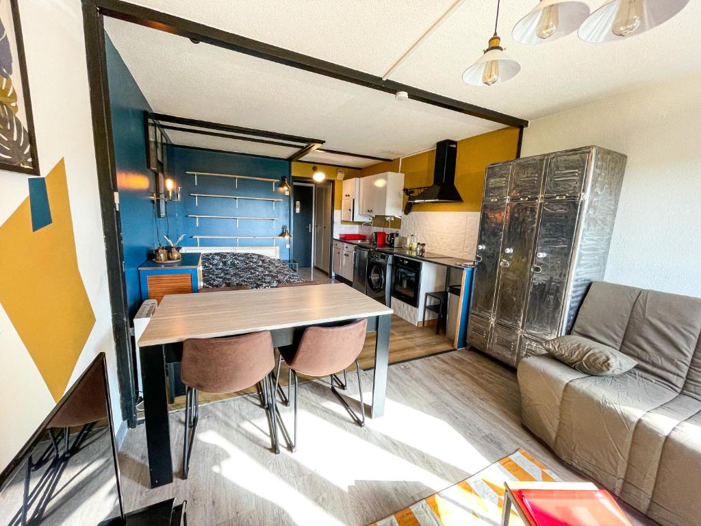 cocina y sala de estar con mesa y sofá en Appartement cosy - Le Chat Gris, en Métabief