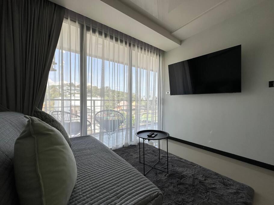 a hotel room with a bed and a flat screen tv at New apartment Rawai Beach 310 by Capital Pro in Phuket