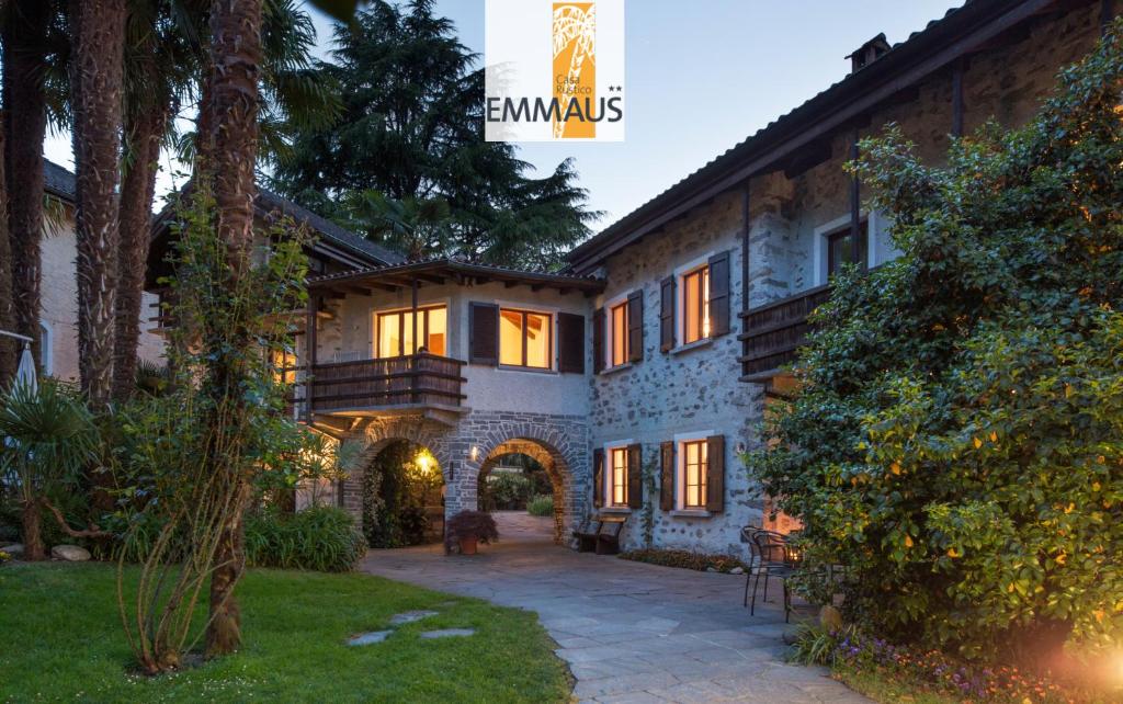 an exterior view of a house with a courtyard at Parkhotel Emmaus - Casa Rustico in Ascona