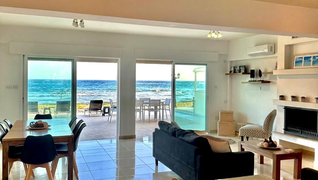 uma sala de estar com vista para o oceano em Sayers Beachfront Villa em Pervolia