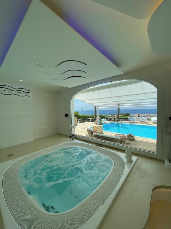 a large bath tub in a room with a large window at Villa Krailo in Santa Maria al Bagno