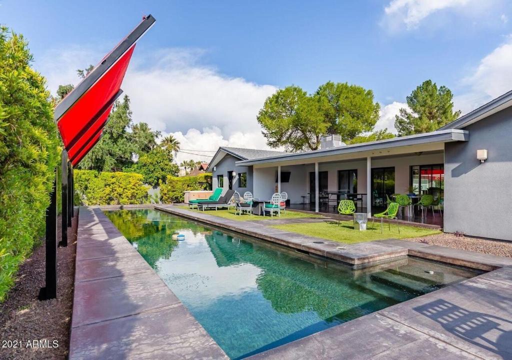 a home with a swimming pool in front of a house at Designer 5 Bd Home, Fountain Pool, Spa, Game Patio in Phoenix
