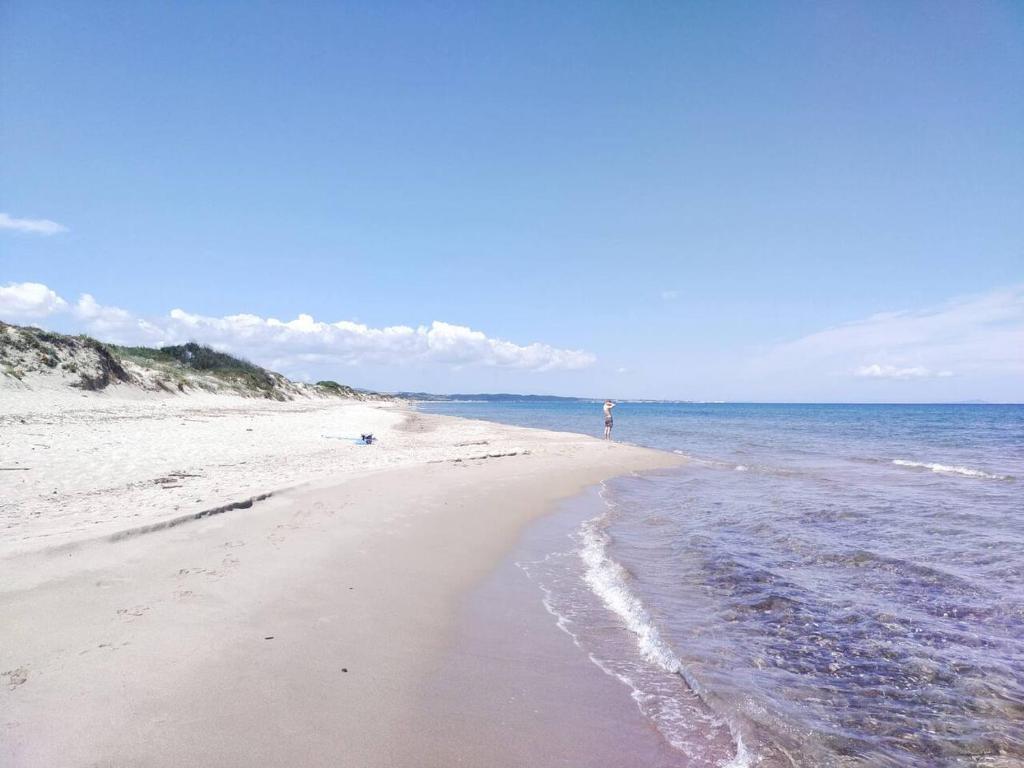 a person standing on a beach near the ocean at Casa a Sorso per le tue vacanza in Sorso