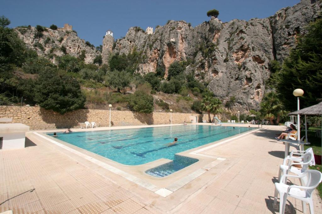 una piscina con una montaña en el fondo en EL ÚNICO apartment with jacuzzi and art en Guadalest