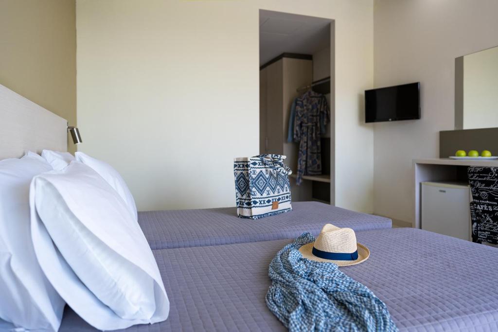 a hat sitting on top of a bed at Cathrin Hotel in Faliraki