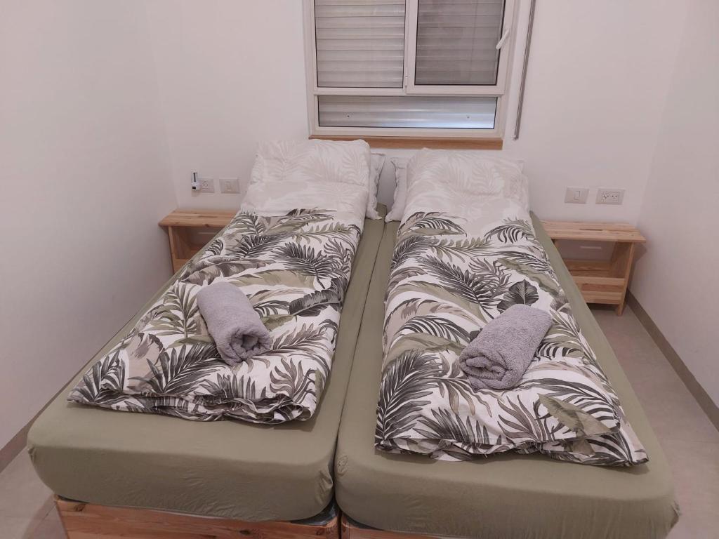 dwa łóżka siedzące obok siebie w pokoju w obiekcie נצר- צימר 