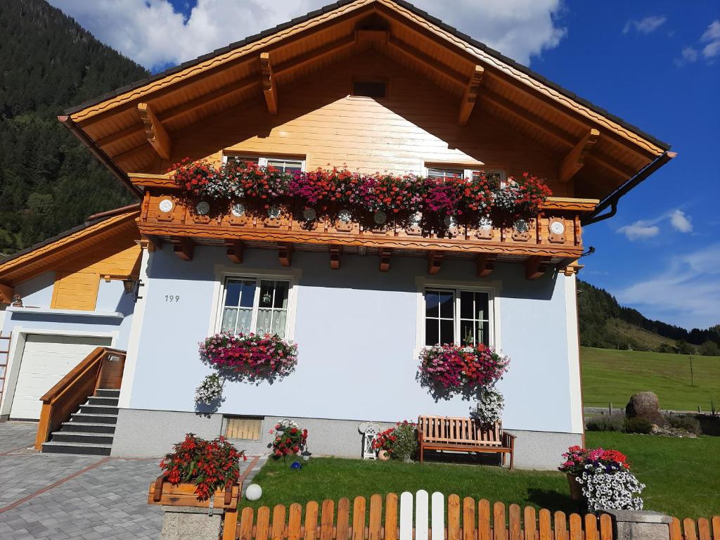 a house with flower boxes on the windows at Bergluft Appartement - Haus Lerchegger in Mössna